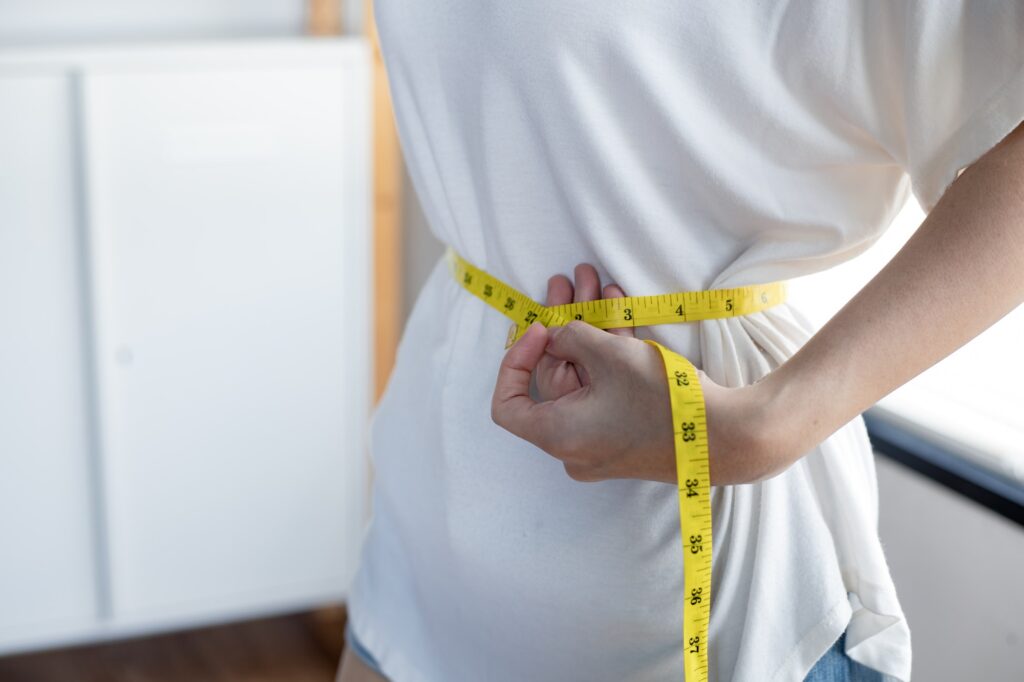 Woman with perfect waist with measuring tape.